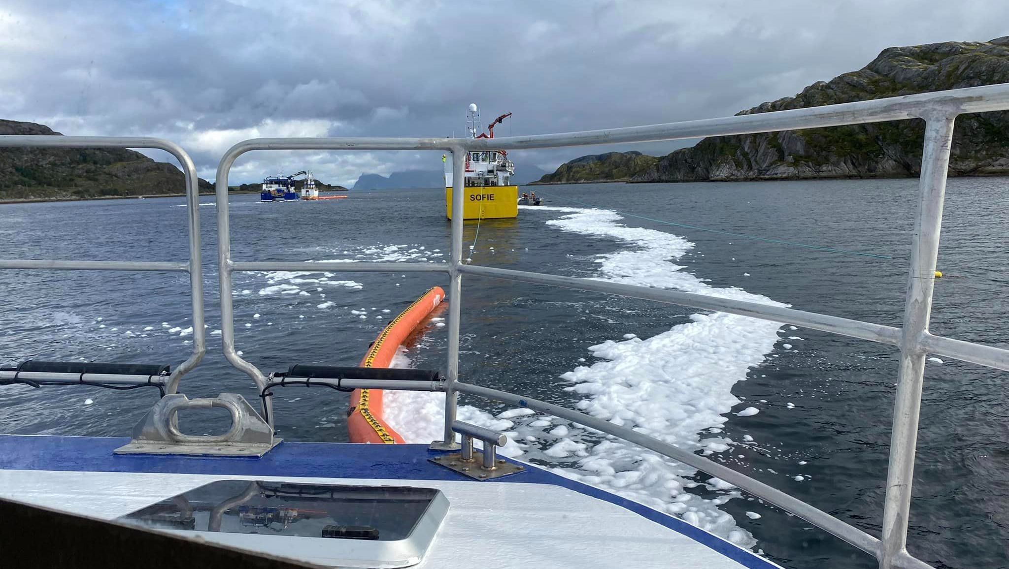 Båt på sjøen med fjell i bakgrunn